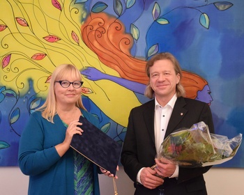 Heikki Karjalainen ja liiton puheenjohtaja Sirpa Alkunen kuvattuna liiton syyskokouksessa. Taustalla näkyvä teos: Voimanainen (2013), Anna Rantakoski